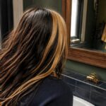 Dark hair with wide blonde streaks and clear contrast between the colors
