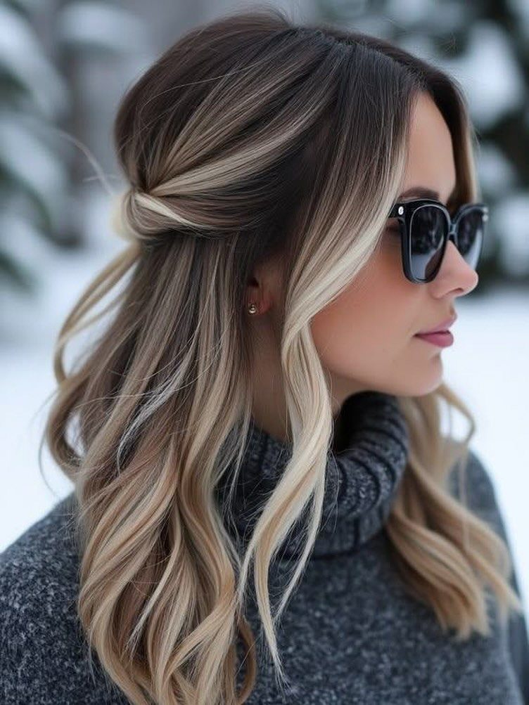 Brunette hair with blonde highlights in loose waves and a pinned side