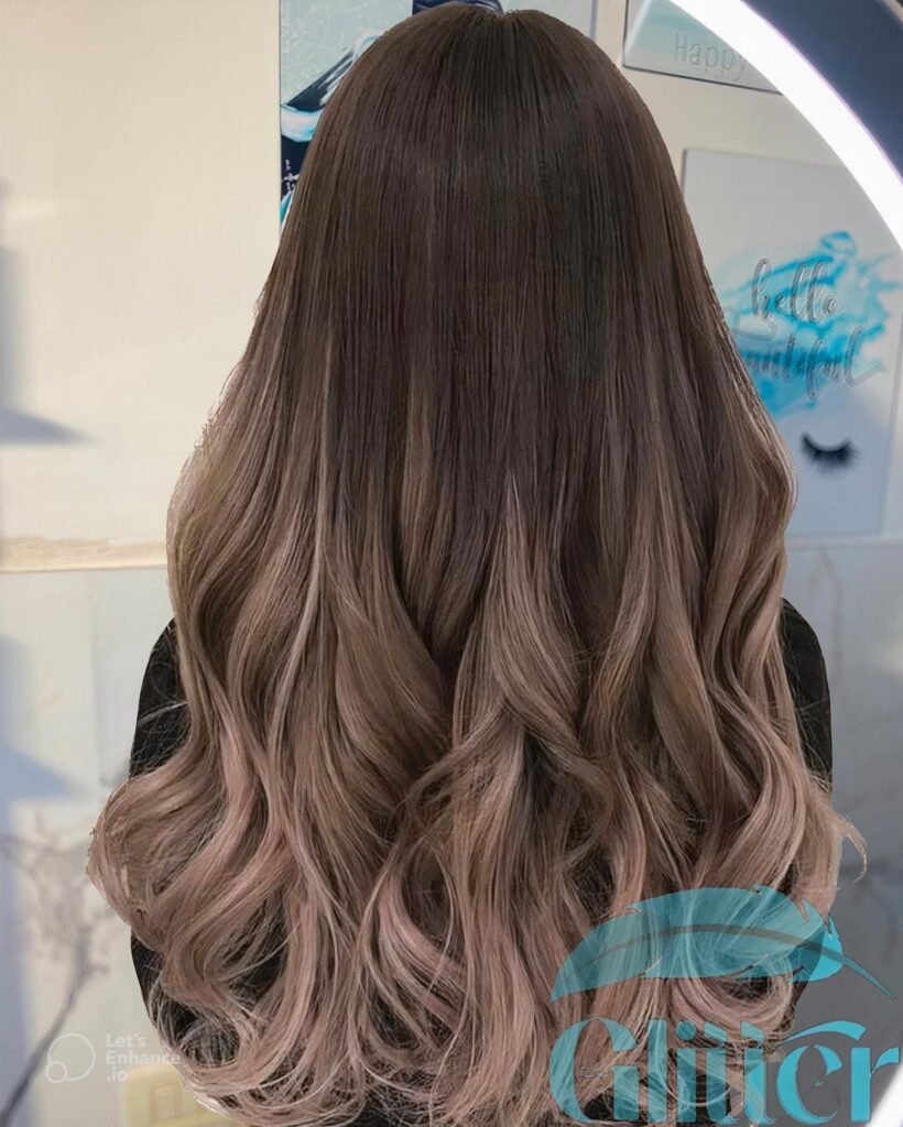Long wavy brown hair fading into mauve-pink ombre curled ends