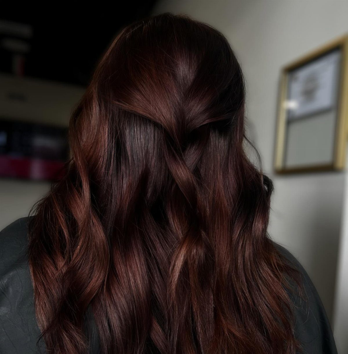 Long wavy dark brown hair with subtle warm reddish-brown highlights