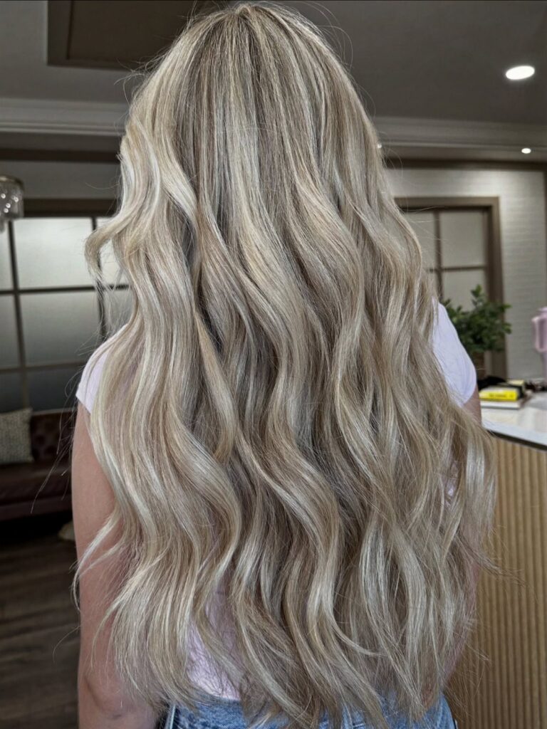 Long wavy blonde hair with bright highlights and darker lowlights