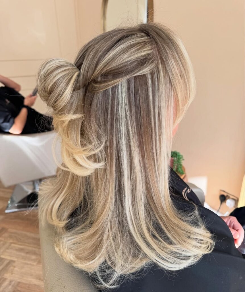 Layered blonde hair with darker lowlights styled in loose salon curls
