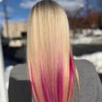 Long blonde hair with vivid pink highlights through the lower lengths