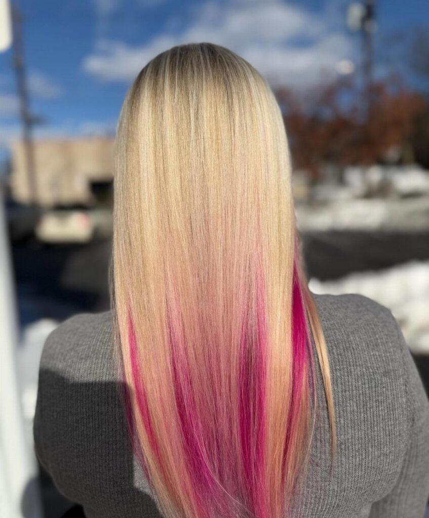 Long blonde hair with vivid pink highlights through the lower lengths