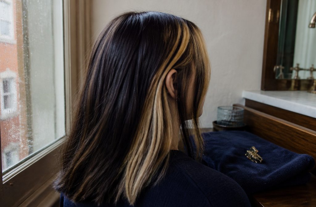 Dark hair with bold chunky highlight ribbons framing the face